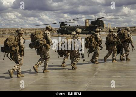 U.S. Marines with Charlie Company, 1st Battalion, 3rd Marine Regiment prepare to embark on a British Royal Air Force CH-47 Chinook aircraft in support of an assault support tactics exercise during Weapons and Tactics Instructor (WTI) course 1-19 at Laguna Army Airfield, Yuma, Arizona, Oct. 3, 2018. WTI is a seven-week training event hosted by Marine Aviation Weapons and Tactics Squadron One (MAWTS-1) which emphasizes operational integration of the six functions of Marine Corps aviation in support of a Marine air-ground task force. WTI also provides standardized advanced tactical training and c Stock Photo
