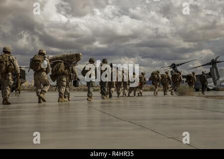 U.S. Marines with Charlie Company, 1st Battalion, 3rd Marine Regiment prepare to embark on an MV-22B Osprey aircraft assigned to Marine Aviation Weapons and Tactics Squadron One (MAWTS-1) in support of an assault support tactics exercise during Weapons and Tactics Instructor (WTI) course 1-19 at Laguna Army Airfield, Yuma, Arizona, Oct. 3, 2018. WTI is a seven-week training event hosted by MAWTS-1 which emphasizes operational integration of the six functions of Marine Corps aviation in support of a Marine air-ground task force. WTI also provides standardized advanced tactical training and cert Stock Photo
