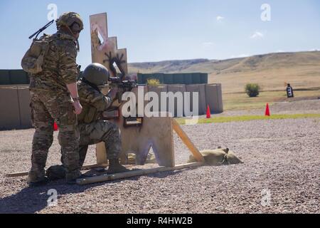 A U.S. Army Green Beret Soldier, assigned to 10th Special Forces Group (Airborne), mentors a critical enabler through a stress shoot at Fort Carson, Colorado, Sept. 28, 2018.  The training showcased their preparedness for future deployments and their readiness to fight at a moments notice. Stock Photo