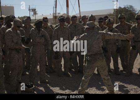 U.S. Marines with Alpha Company, 1st Battalion, 3d Marine Regiment, receive instruction prior to conducting a fast-rope training event during Talon Exercise (TalonEx) 2018 at Yuma Proving Grounds, Arizona, Sept. 21, 2018. TalonEx is a pre-deployment exercise in conjunction with the Weapons and Tactics Instructors Course that gives Marine ground combat elements the opportunity to work directly with air combat elements in real world scenarios. Stock Photo