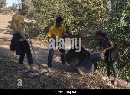 SAN DIEGO (Oct. 26, 2018) Ensign Grace Albertson, a native of St. Paul, Minn. and Quatermaster 3rd Class Christopher Quin, a native of St. Mary, Ga. help a student spread mulch at an Earth Lab Project with Millennial Middle School during San Diego Fleet Week (SDFW) 2018. SDFW is an opportunity for the American public to meet their Navy, Marine Corps and Coast Guard teams and experience America’s sea services. During fleet week, service members participate in various community service events, showcase capabilities and equipment to the community, and enjoy the hospitality of San Diego and its su Stock Photo