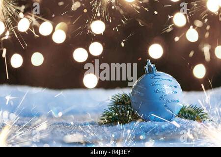 Christmas ball with sparklers and garlands on the snow Stock Photo