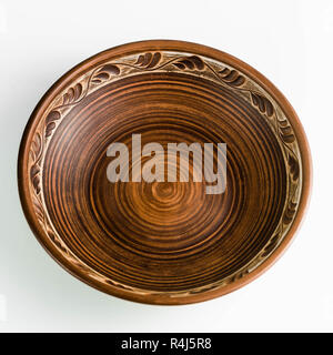 pots and plates of clay on a white table and a blue background. clay pottery kitchen utensils made by hand. red clay tableware Stock Photo