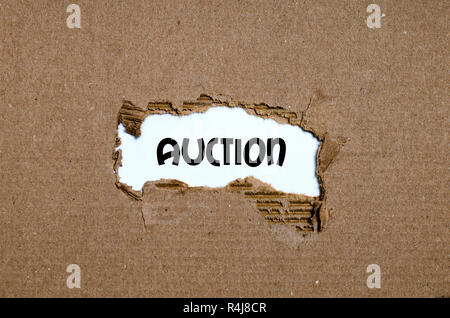 The word auction appearing behind torn paper Stock Photo