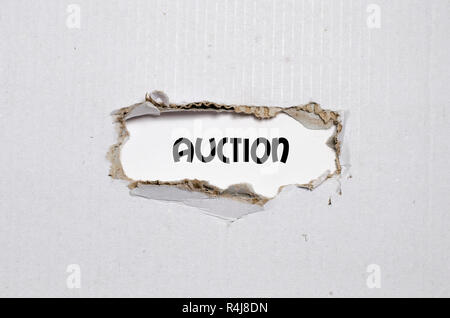 The word auction appearing behind torn paper Stock Photo