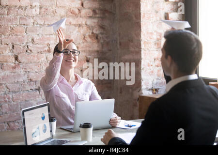 Office workers launching paper planes together in office. Stock Photo