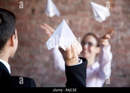 Office workers launching paper planes together in office. Stock Photo