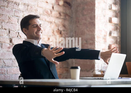 Smiling businessman doing relaxing exercise in workplace. Stock Photo