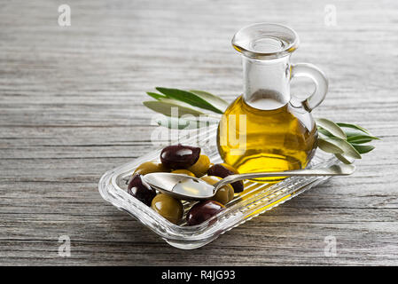 Bottle of Extra virgin healthy Olive oil with fresh olives close up Stock Photo