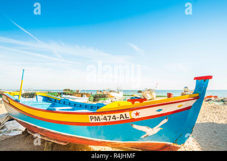 traditional colourful hand-painted wooden fishing boats  in front of fishing huts at fisherman´s beach Stock Photo