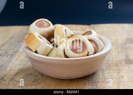 Sausages rolled in croissant dough baked cooling on metal rack. Stock Photo