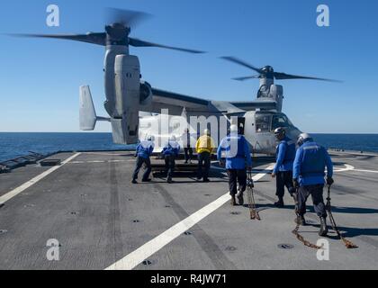 ATLANTIC OCEAN (Oct. 30, 2018) – Sailors move to secure an MV-22 Osprey after it lands on the flight deck of the amphibious dock landing ship USS Fort McHenry (LSD 43) as part of the Carrier Strike Group (CSG) 4 composite training unit exercise (COMPTUEX). COMPTUEX is the final pre-deployment exercise that certifies the combined Kearsarge Amphibious Ready Group (ARG) and 22nd Marine Expeditionary Unit’s (MEU) abilities to conduct military operations at sea and project power ashore through joint planning and execution of challenging and realistic training scenarios. CSG 4 mentors, trains and as Stock Photo