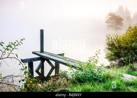 footbridge at the lake with fog in the morning Stock Photo