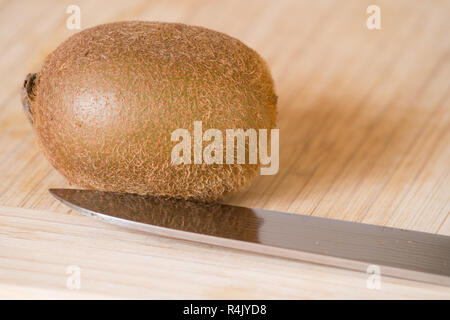 Close-up of a sliced Kiwi fruit on a wooden board. Stock Photo