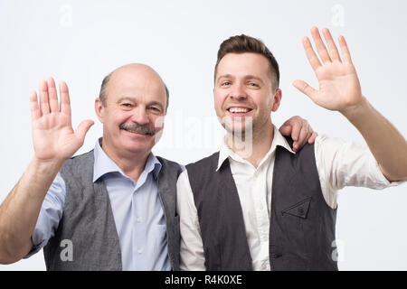 Two men saying hello, waving a hand Stock Photo