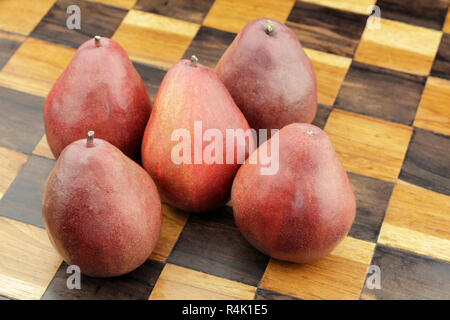 Five Red Pears on a Wooden Chessboard Stock Photo