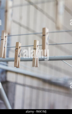Wooden clothespins on a clothesline, blur, light photo. The concept of eco-consumption, the use of natural materials, awareness. Stock Photo