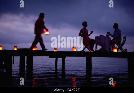 Mature couple toasting during their romantic dinner on the pier. Stock Photo