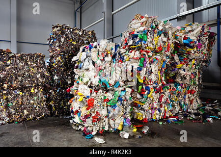 Compressed bales of polyethylene used PET bottles from drinks and detergents sorted and packaged for further processing workshop at modern waste recyc Stock Photo