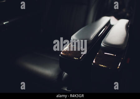 Luxury car inside. Interior of prestige modern car. Comfortable leather seats. Black perforated leather cockpit with isolated black background. Stock Photo