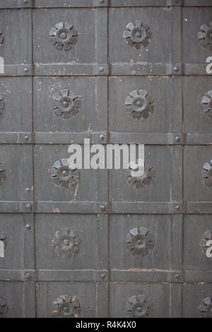 A large massive ancient metal wrought-iron black door Stock Photo