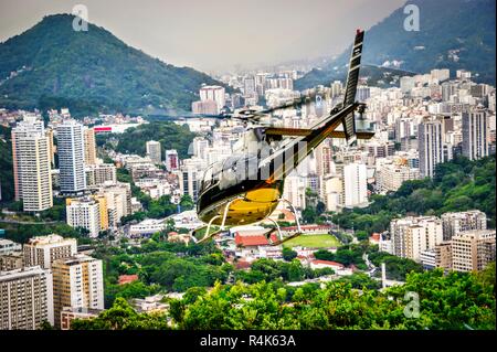 Close-up of a helicopter flying over the impressive skyline of Rio de Janeiro, Brazil Stock Photo