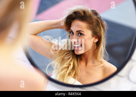 Beautiful blonde Caucasian woman posing in bathroom with wet hair Stock Photo