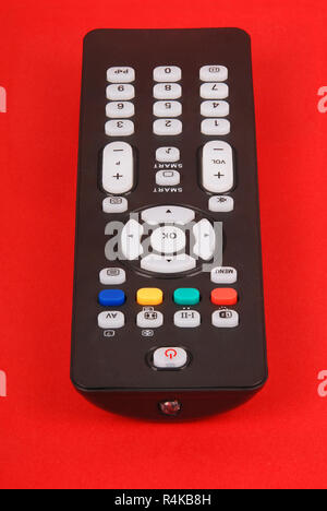 Black remote control for TV isolated on red background Stock Photo
