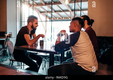 Arabian young men hanging in loft cafe. Middle-eastern people talking and having fun in lounge bar and having drinks. Friends chilling out and relaxin Stock Photo