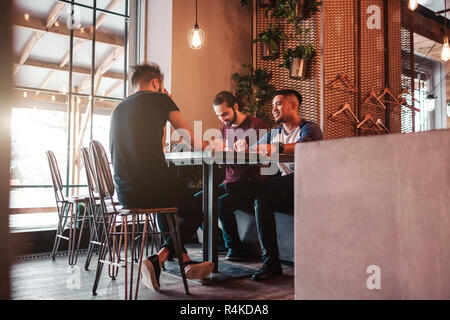 Group of arab friends taking selfie in lounge bar. Mixed race young men having fun in loft cafe Stock Photo