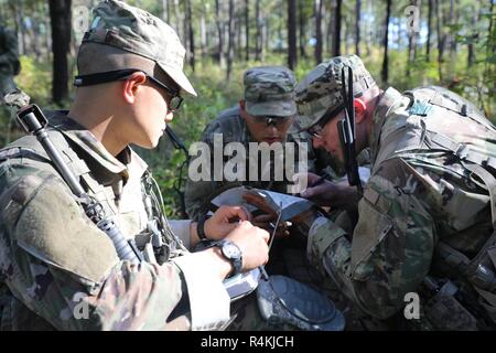 A group of U.S. Army Pre-Ranger Students, looks over the route to the objecive on a map during Pre-Ranger School at Training Area Echo, Fort Benning, GA., October 28, 2018. Pre-Ranger School provides guidance and mentorship for students to be successful as they prepare to attend Ranger School. Stock Photo