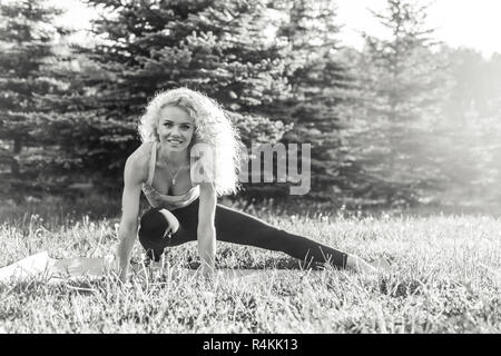 Image of young curly-haired sports woman practicing yoga on rug  Stock Photo