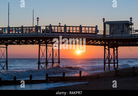 Low sun over the sea at an Autumn sunset on the coast by Worthing Pier, West Sussex, England, UK.