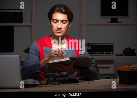 Young handsome repairman repairing computer Stock Photo