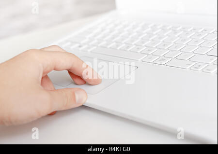 mans hand touching touchpad by finger. white style workspace technics Stock Photo