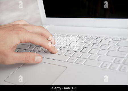 mans hand typing on white keyboard by fingers. white style workspace technics Stock Photo
