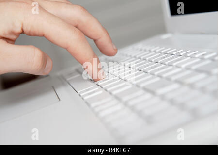 mans hand typing on white keyboard by fingers. white style workspace technics Stock Photo