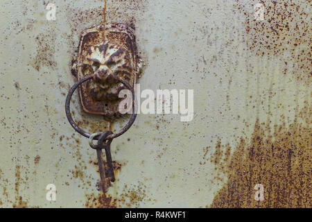 vintage shabby door iron lock in lion shape with keys on the ring Stock Photo