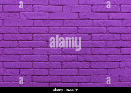ultraviolet brick wall painted at saturated purple colour. closeup texture background Stock Photo
