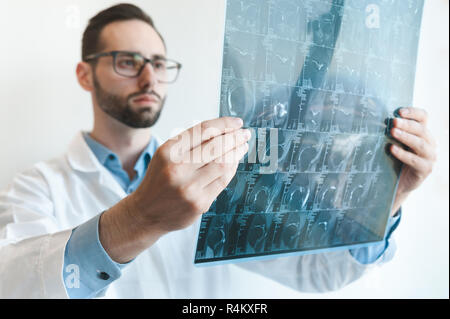 young doctor looking at Magnetic resonance imaging shot of knee-joint. meniscus injury. blurred Stock Photo