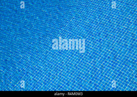 Detail of mosaic tile floor in a swimming pool seen through rippled water. Stock Photo