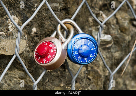 Two Padlocks Combination closed on a metal grid Stock Photo