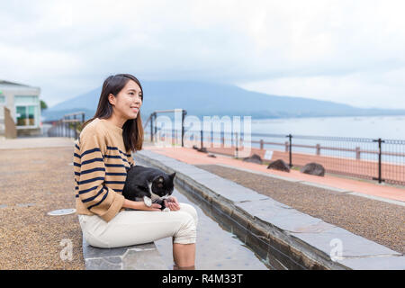 Woman enjoy foot onsen with cat at outdoor Stock Photo