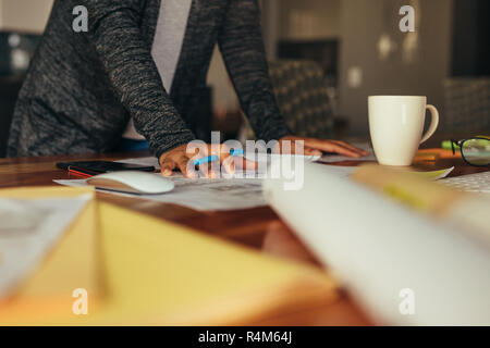 Cropped shot of woman designer working on building plan. Interior designer hands preparing a working on a drawing. Stock Photo