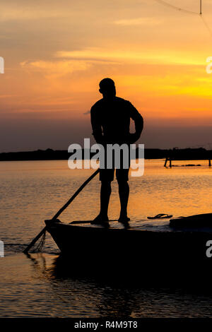 Silhouette of a man fishing from a boat at sunset Stock Photo - Alamy