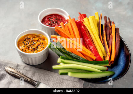 Colorful vegetable sticks in a blue plate on grey background Stock Photo