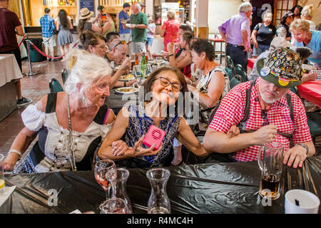 Elderly diners happily sway to the music of a German band at an Oktoberfest gathering in Huntington Beach, CA. Stock Photo
