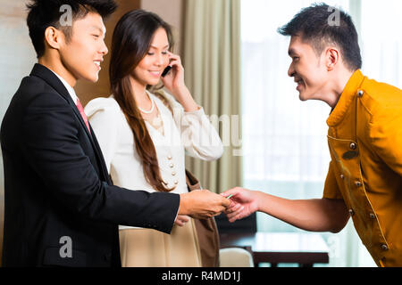 Asian Chinese bell boy or porter receiving tip Stock Photo