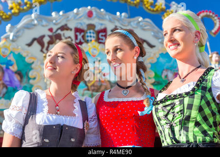 Friends visiting Bavarian fair having fun Stock Photo