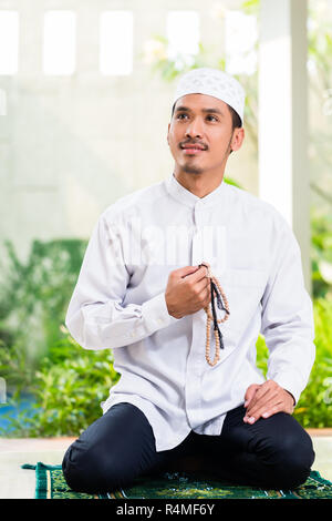 Asian Muslim man praying at home Stock Photo